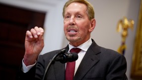 Business meeting with diverse professionals discussing strategies, seated around a conference table with documents and lap...