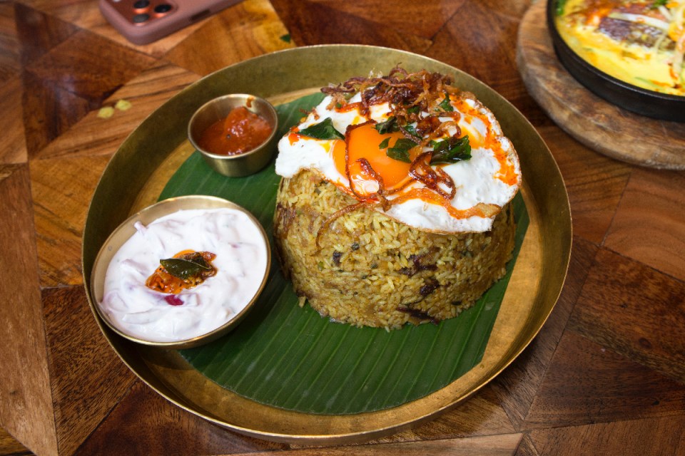 Delicious Sri Lankan Hoppers and aromatic biryani garnished with fresh herbs on a beautifully set dining table