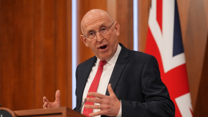 John Healey delivering a speech at a press conference, emphasizing key points on current political issues and policies.