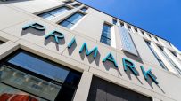 Primark storefront with shoppers entering and exiting, showcasing the latest fashion trends and bustling retail activity.