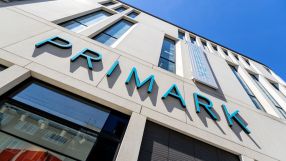 Primark storefront with shoppers entering and exiting, showcasing the latest fashion trends and bustling retail activity.