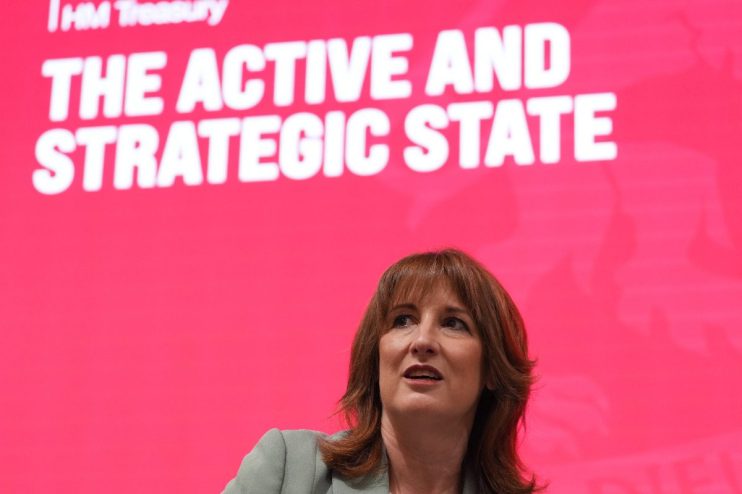 Rachel Reeves discussing economic strategies amid forecasts of low growth for the year at a business conference podium.