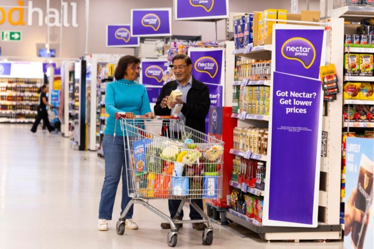 Sainsburys supermarket exterior with customers entering and exiting, showcasing the stores vibrant signage and busy atmosp...