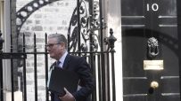 Keir Starmer exiting Number 10 Downing Street after a meeting, showcasing UK political leadership and discussions