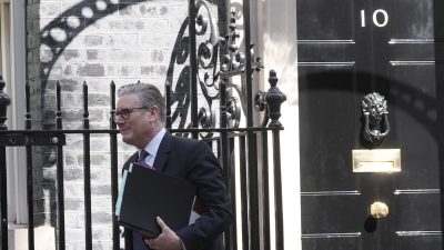 Keir Starmer exiting Number 10 Downing Street after a meeting, showcasing UK political leadership and discussions