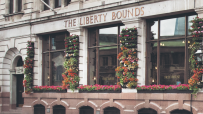 The Liberty Bounds Wetherspoons pub exterior with patrons and bustling street scene in central London