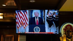 Donald Trump speaking at a press conference with American flags in the background, emphasizing political stance and leader...