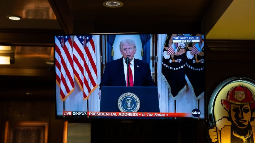 Donald Trump speaking at a press conference with American flags in the background, emphasizing political stance and leader...