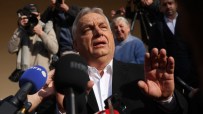 Hungarian Prime Minister Viktor Orban speaking at a press conference, gesturing with his hands, with a serious expression.