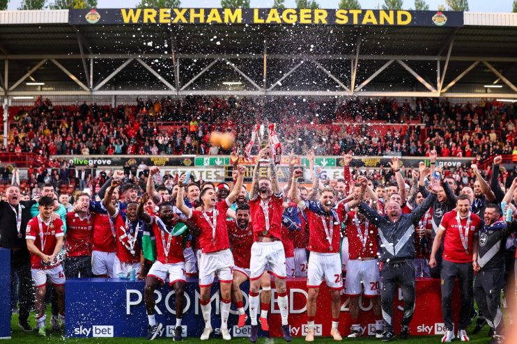 Wrexham cityscape featuring historic buildings and bustling streets under a clear blue sky, highlighting local architectur...