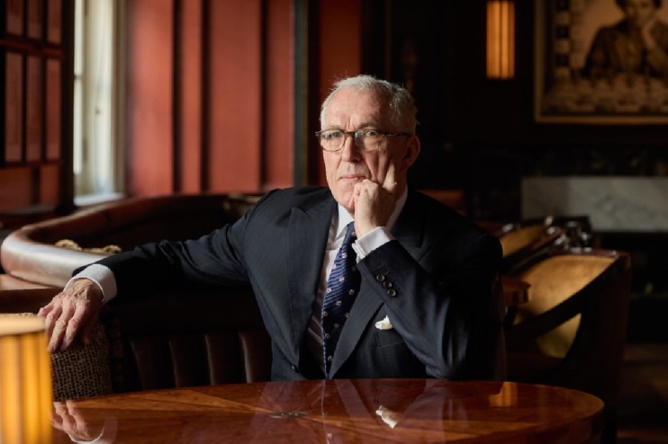 Jeremy King addressing the audience at a business conference, wearing a suit and gesturing while standing at the podium.