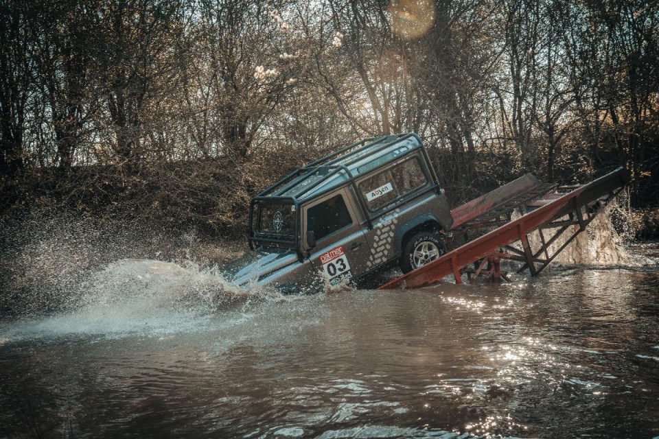 Land Rover showcasing rugged terrain capabilities in a scenic landscape setting, highlighting its off-road performance fea...