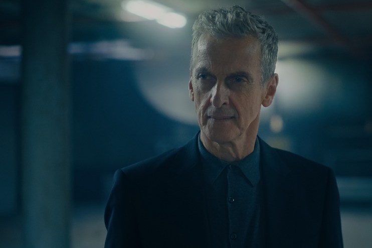 Peter Capaldi smiling in a suit at a public event, showcasing his charismatic presence and style.