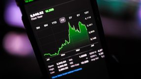 Graph showing fluctuating stock prices with green and red arrows indicating market trends on financial news website
