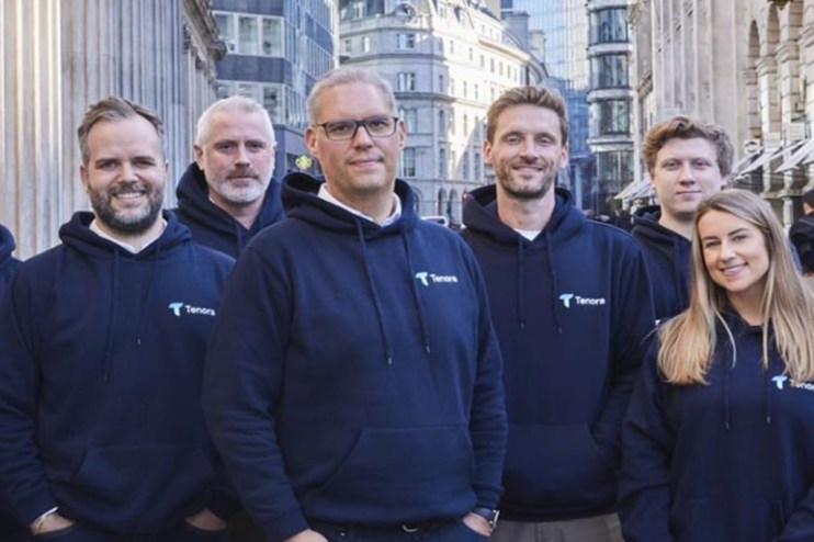 Tenora staff members in a professional meeting discussing business strategies and developments in a modern office setting