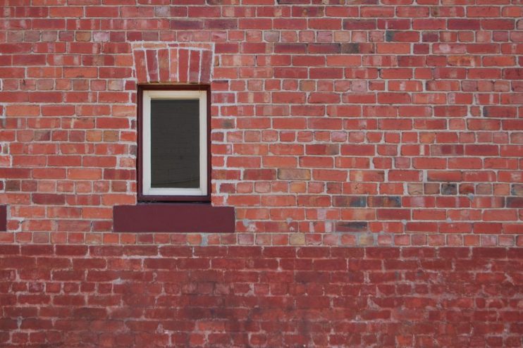 Modern office building with large glass windows reflecting the cityscape, illustrating architectural design trends