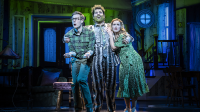 Beetlejuice musical cast performing on stage at the London production, showcasing vibrant costumes and set design