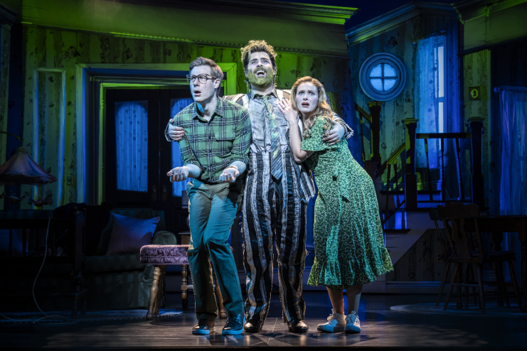 Beetlejuice musical cast performing on stage at the London production, showcasing vibrant costumes and set design