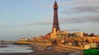 Blackpool skyline at sunset with iconic tower and bustling promenade, highlighting vibrant seaside town atmosphere