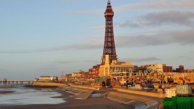 Blackpool skyline at sunset with iconic tower and bustling promenade, highlighting vibrant seaside town atmosphere
