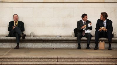 Businessman eating lunch outdoors in City of London financial district