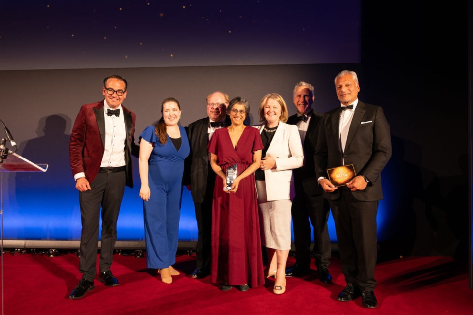 Hogan Lovells team celebrates City AM Awards victory, showcasing joy and achievement in a prestigious business event setting