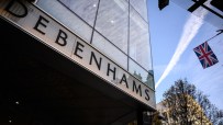 Debenhams storefront in central London showcasing seasonal window displays and iconic signage on a bustling street.