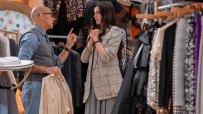 Anne Hathaway in a cut scene from Devil Wears Prada 2, wearing a stylish outfit, surrounded by high fashion elements.