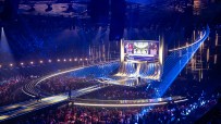 Eurovision stage with vibrant lights and performers captivating an enthusiastic audience during the live music competition.