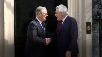 Gordon Brown and Keir Starmer engaged in discussion at a political event, highlighting leadership and policy collaboration