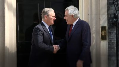 Gordon Brown and Keir Starmer engaged in discussion at a political event, highlighting leadership and policy collaboration