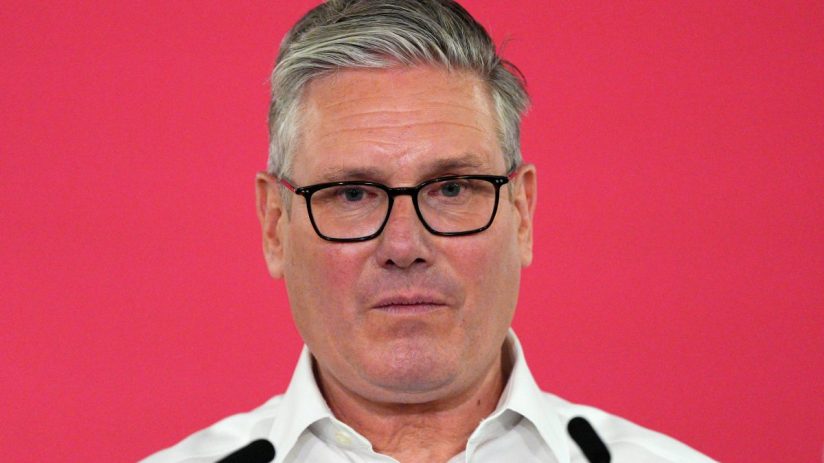 Keir Starmer delivering a speech on May 11, addressing political issues, in a formal setting with an audience.
