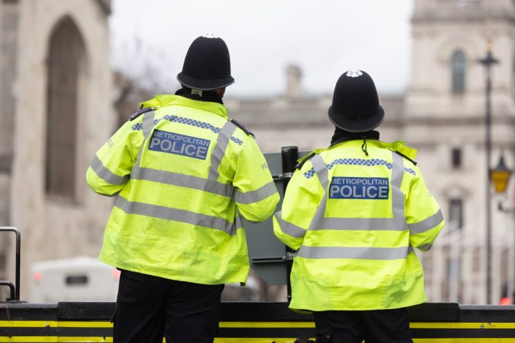London police officers patrolling the streets, ensuring public safety and security during a busy day in the city.