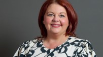 Paula Barker speaking on bond markets aligning with Andy Burnhams economic views, addressing audience at conference.