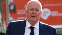 Peter Murrell at a press conference, addressing the media with a focused expression against a backdrop of journalists and ...