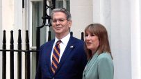 Scott Besent and Rachel Reeves discussing economic strategies at a business conference podium