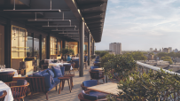London skyline view from a rooftop bar in Kensington and Chelsea, featuring stylish seating and vibrant evening atmosphere