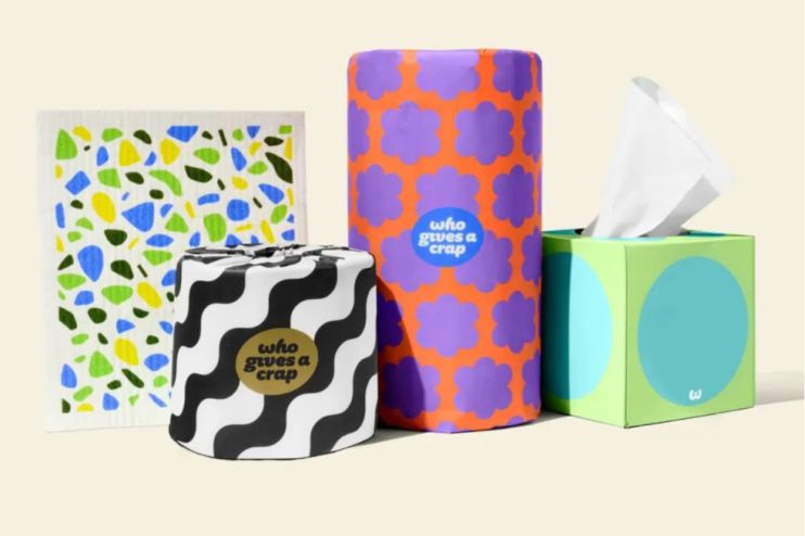 Eco-friendly toilet paper rolls from Who Gives a Crap company displayed in sustainable packaging on a wooden surface