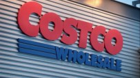 Costco storefront with customers entering and exiting, showcasing the bustling atmosphere of a popular retail warehouse chain