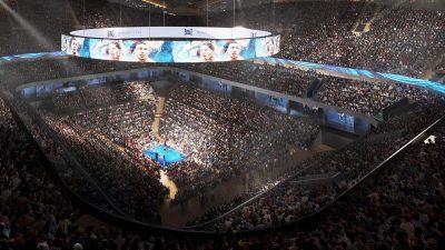 Interior of Londons Colosseum Arena set up for a boxing event, featuring a large ring and tiered seating under bright lights