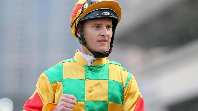 Jockey Zac Purton riding a racehorse during a competitive event, showcasing his skill and determination on the racetrack.