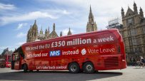 Red bus with Brexit misinformation slogan parked on a street, highlighting controversial political claims and public react...