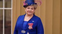 Emily Thornberry addressing media at press conference, wearing a navy blazer, standing at a podium with microphones
