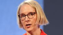 Emma Reynolds speaking at a business conference podium, engaging audience with insights on industry trends and strategies.
