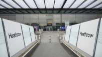 Heathrow Airport terminal bustling with travelers and staff, showcasing modern architecture and international flight activity