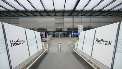 Heathrow Airport terminal bustling with travelers and staff, showcasing modern architecture and international flight activity