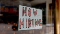 Prominent hiring sign displayed in front of a business, indicating job vacancies and employment opportunities
