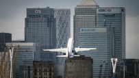 London City Airport terminal bustling with travelers and staff, showcasing modern architecture and vibrant city backdrop.