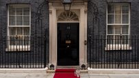 Number 10 Downing Street entrance with iconic black door and brass letterbox, symbolizing UK Prime Ministers official resi...