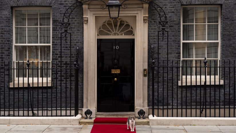 Number 10 Downing Street entrance with iconic black door and brass letterbox, symbolizing UK Prime Ministers official resi...